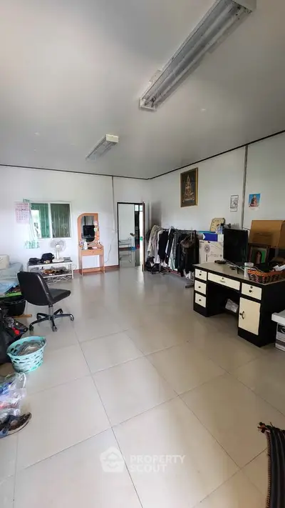 Spacious home office with modern furniture and ample natural light, perfect for productivity and comfort.