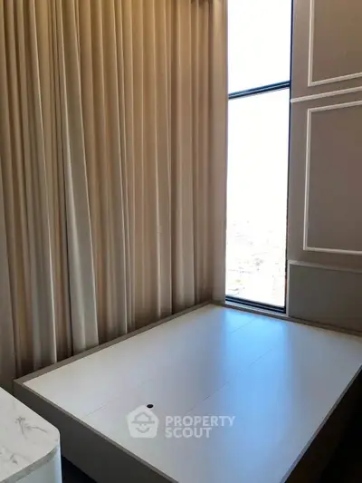 Elegant bedroom corner with floor-to-ceiling window and luxurious drapes