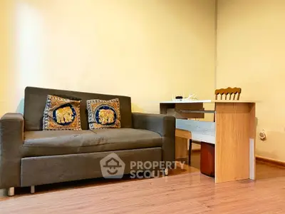 Cozy living room with stylish sofa and modern wooden desk, perfect for a comfortable home office setup.