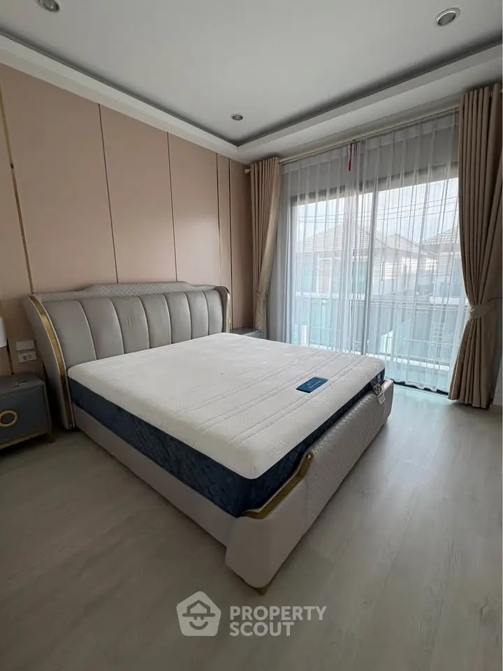 Spacious bedroom with elegant bed and large window offering natural light.