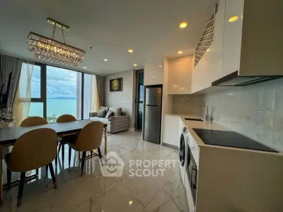 Luxurious open-plan living room with ocean view and modern kitchen appliances.