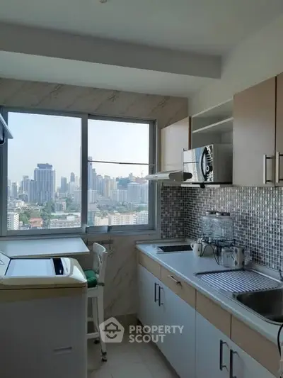 Modern kitchen with city view, featuring sleek cabinets and mosaic backsplash.