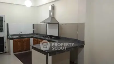 Modern kitchen with sleek countertops and gas stove in a spacious layout.