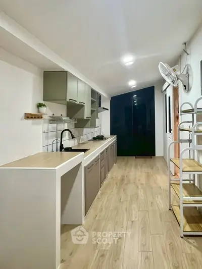 Modern kitchen with sleek cabinetry and wooden flooring