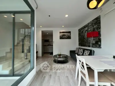 Modern living room with stylish decor and open layout, featuring a cozy seating area and dining space.