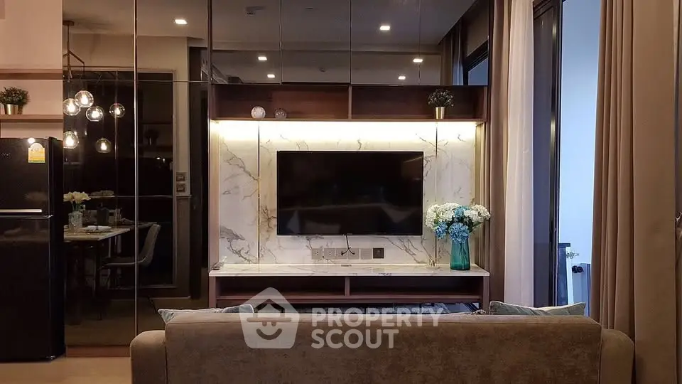 Luxurious modern living room with elegant decor and ambient lighting, featuring a sleek TV setup and stylish furnishings.