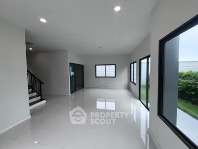 Spacious modern living room with large windows and sleek tile flooring