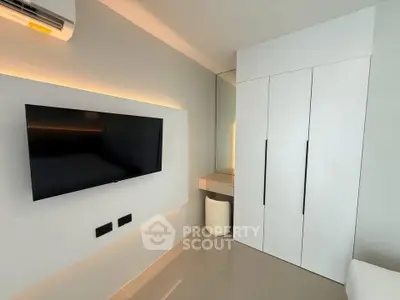 Modern bedroom with sleek TV setup and stylish wardrobe
