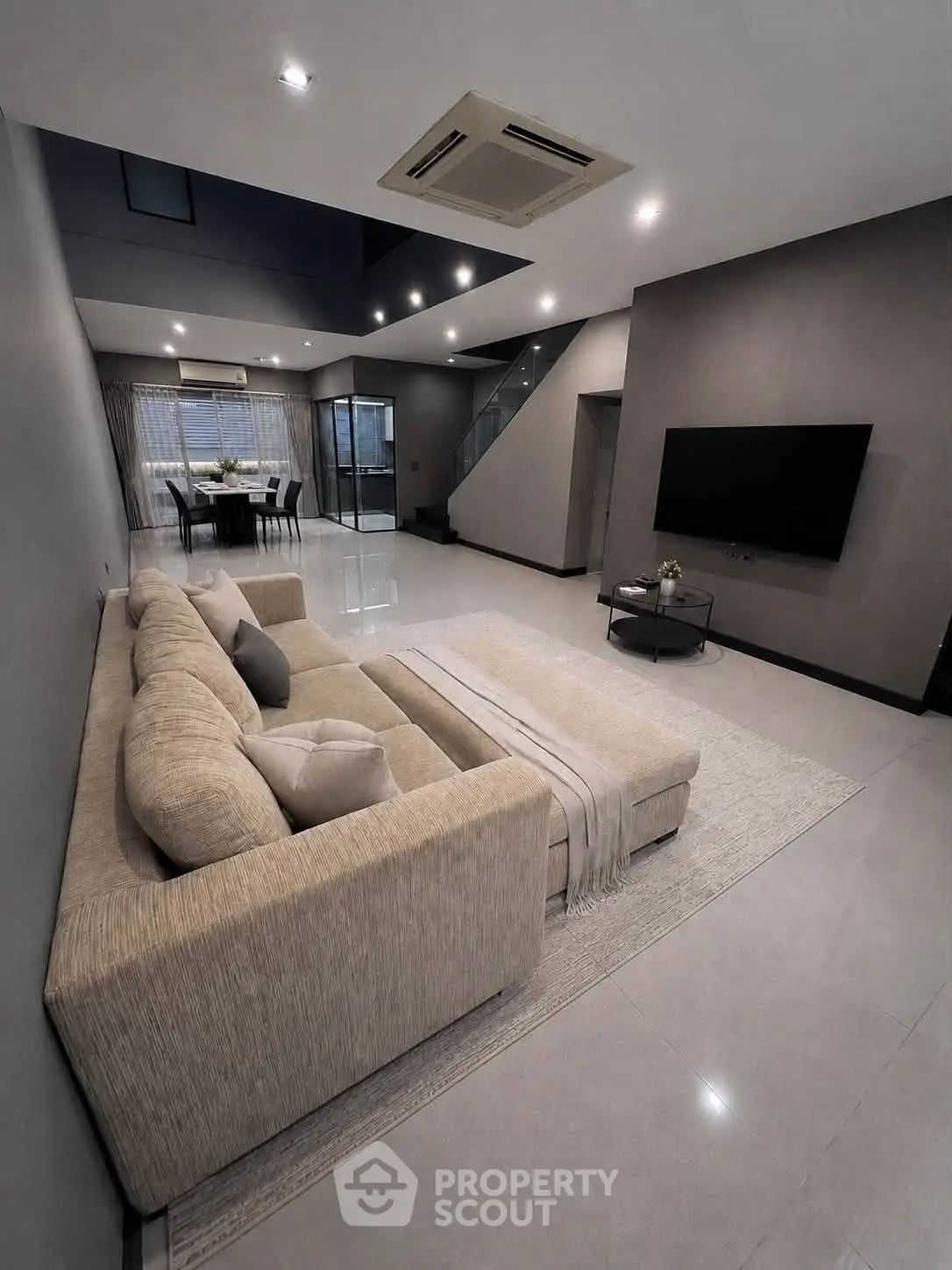 Spacious modern living room with elegant decor and open dining area, perfect for entertaining.