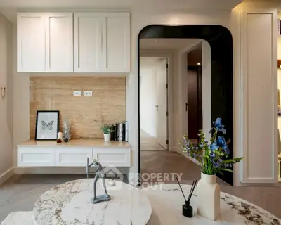 Modern living room with elegant decor and stylish furniture, featuring a marble coffee table and artistic accents.