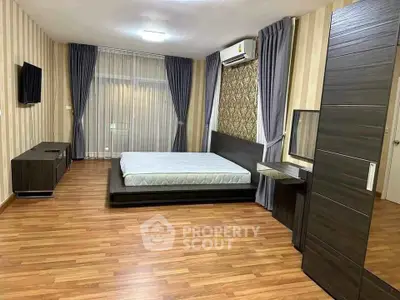 Spacious modern bedroom with wooden flooring and stylish decor