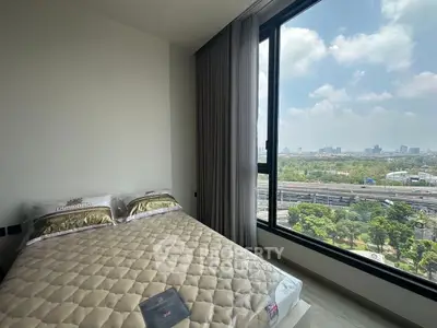 Modern bedroom with large window offering stunning city view