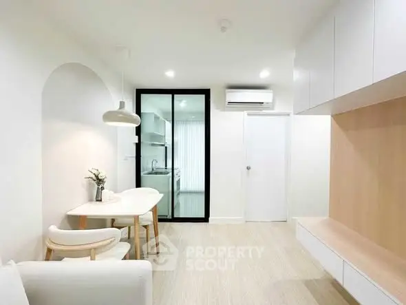 Modern minimalist living room with sleek furniture and open kitchen layout.