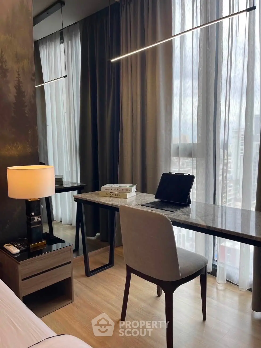 Modern study area with sleek desk, chair, and large window view in stylish apartment.