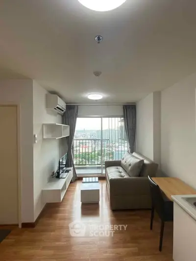 Modern living room with balcony view, featuring sleek furniture and abundant natural light.