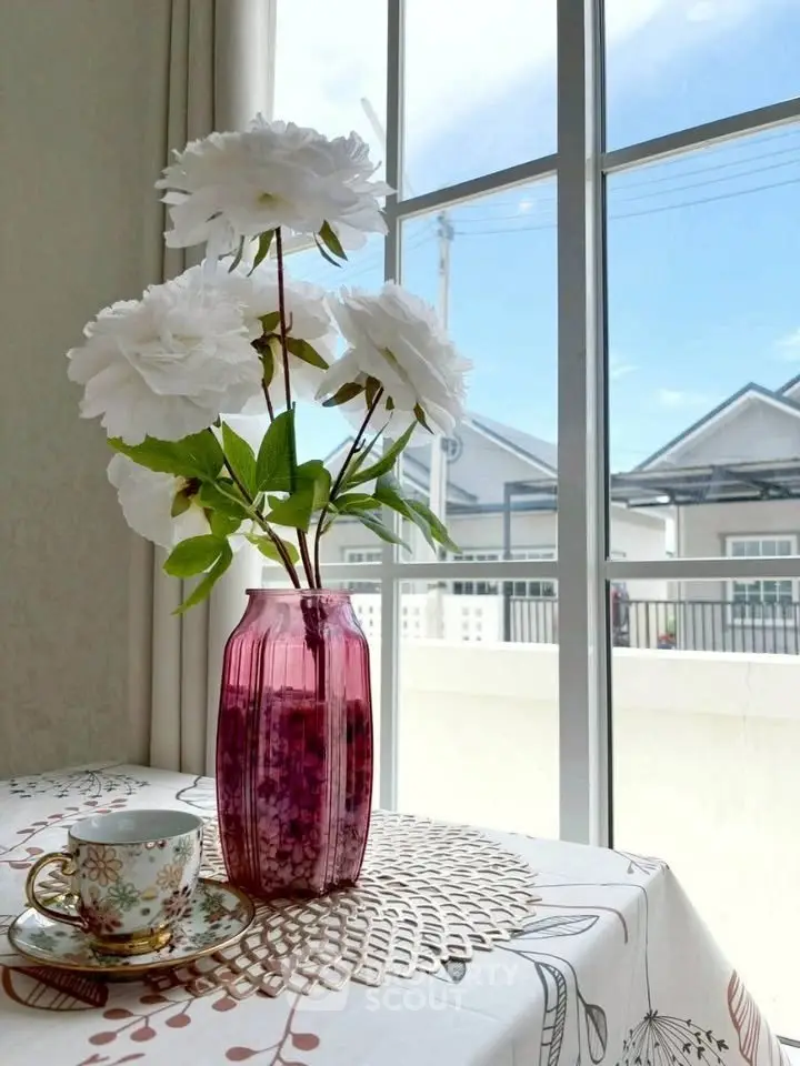 Charming interior with floral decor and bright window view, perfect for cozy living spaces.