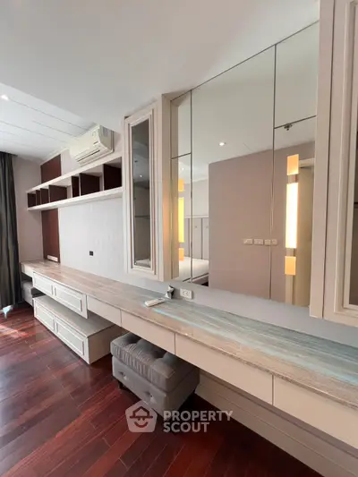 Spacious bedroom with elegant built-in vanity and wooden flooring