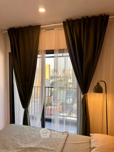 Cozy bedroom with city view, featuring elegant curtains and warm lighting, perfect for urban living.