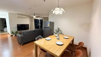 Spacious modern living room with dining area and sleek furniture in open layout apartment.