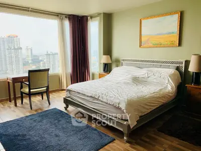 Spacious bedroom with city view, elegant decor, and natural light in modern apartment.