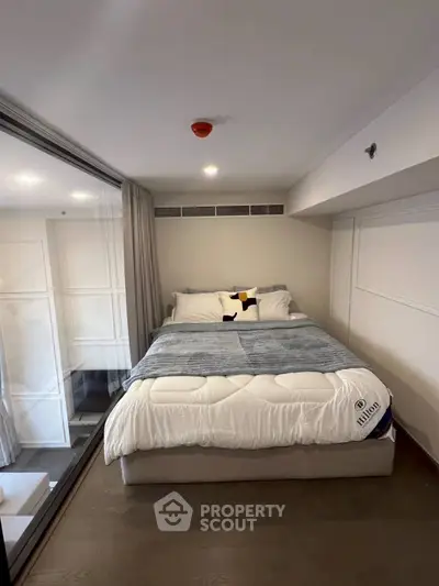 Cozy bedroom with modern decor and large window for natural light.