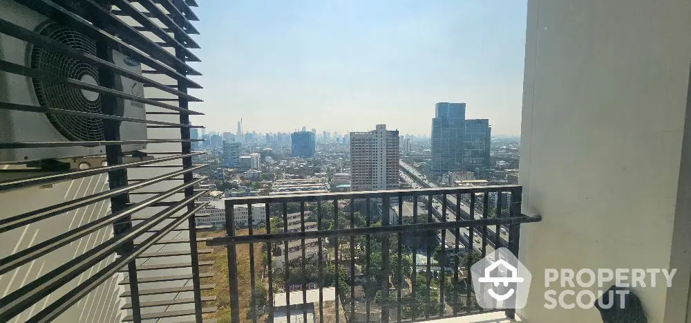 Stunning cityscape view from a high-rise balcony with modern railing and air conditioning unit.