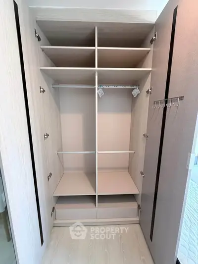 Spacious modern wardrobe with ample shelving and hanging space in a stylish bedroom.