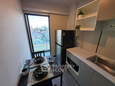 Modern kitchen with city view, featuring sleek appliances and stylish dining setup.