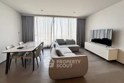 Modern living room with sleek furniture and large windows offering natural light.
