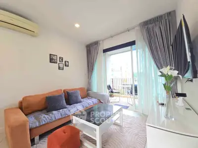 Modern living room with cozy sofa, wall-mounted TV, and balcony access in stylish apartment.