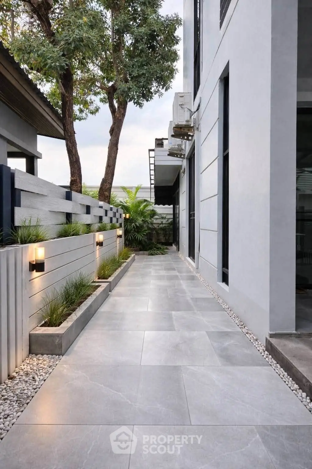 Modern exterior walkway with sleek tiles and ambient lighting in a contemporary home setting.