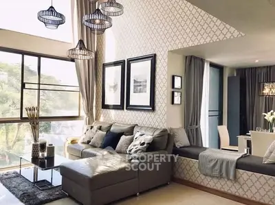 Luxurious living room with elegant decor and large windows offering natural light.