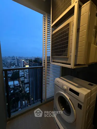 High-rise balcony with city view and laundry appliances at dusk.