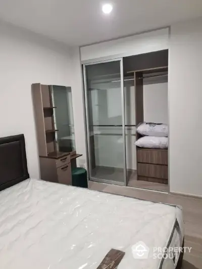 Modern bedroom with sleek wardrobe and cozy bed setup