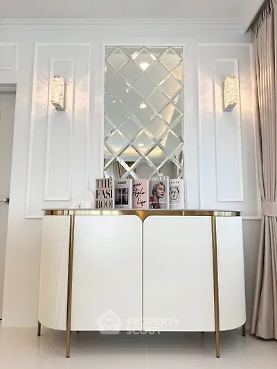 Elegant interior with mirrored wall and stylish console table in modern living space.
