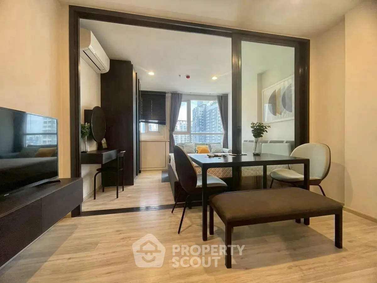 Modern living room with dining area and city view, featuring sleek furniture and elegant decor.