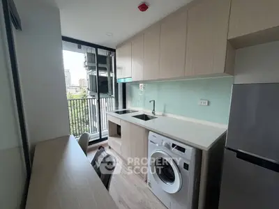 Modern kitchen with washing machine and balcony view in urban apartment
