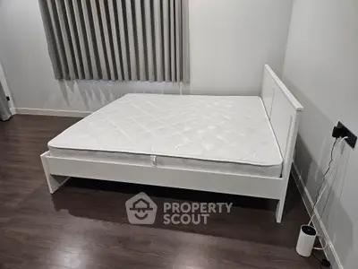 Modern bedroom with sleek white bed frame and elegant curtains