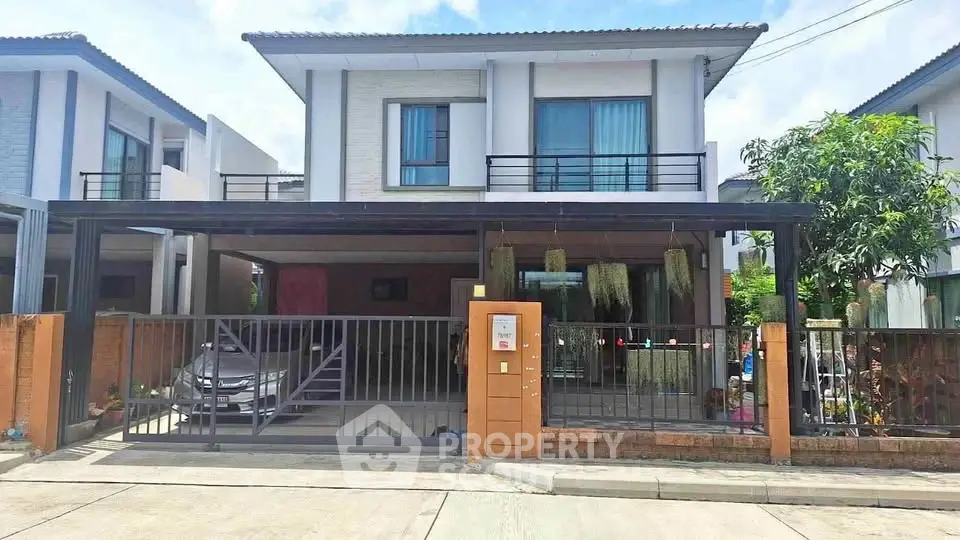 Modern two-story house with carport and gated entrance in suburban neighborhood.