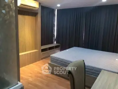 Spacious modern bedroom with elegant wooden flooring and stylish furnishings.