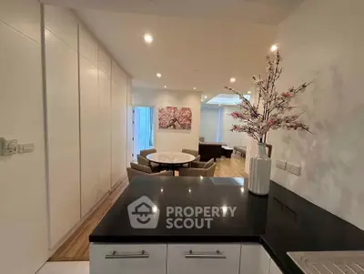 Modern open-plan kitchen and dining area with elegant decor and recessed lighting.