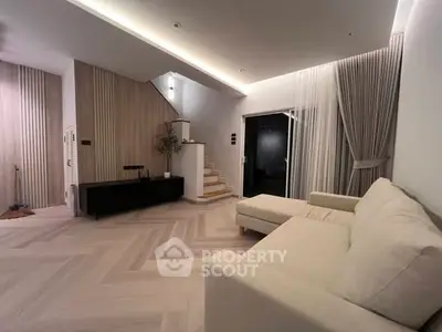 Modern living room with elegant staircase and cozy sofa