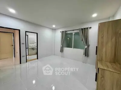 Spacious unfurnished bedroom with large window and modern tile flooring