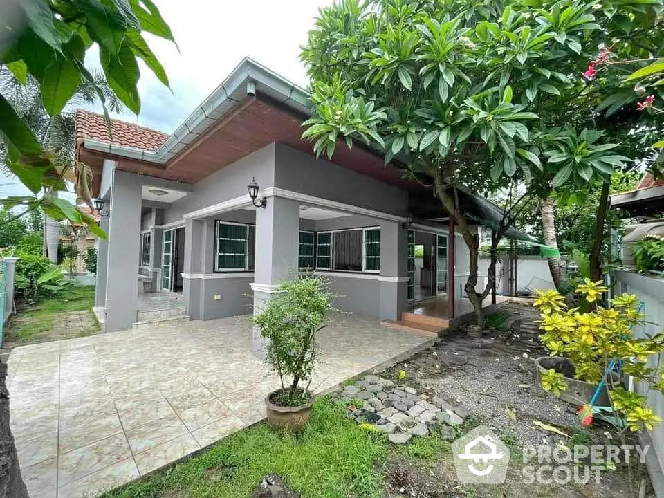 Charming single-story home with lush garden and tiled patio, perfect for outdoor relaxation.