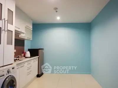 Modern kitchen with sleek appliances and vibrant blue accent wall