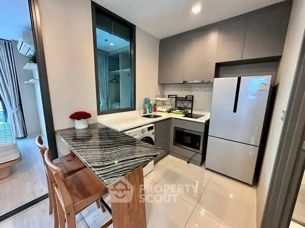 Modern kitchen with sleek appliances and stylish breakfast bar in a compact layout.