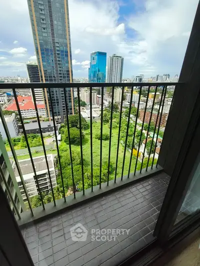 Stunning high-rise balcony view overlooking cityscape and lush greenery, perfect for urban living.
