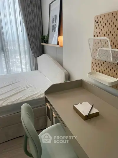 Modern bedroom with study area, featuring sleek desk and comfortable chair, large window with city view.