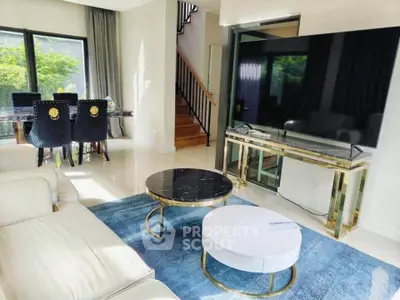Luxurious living room with modern decor, large TV, and elegant furniture in a bright, spacious setting.