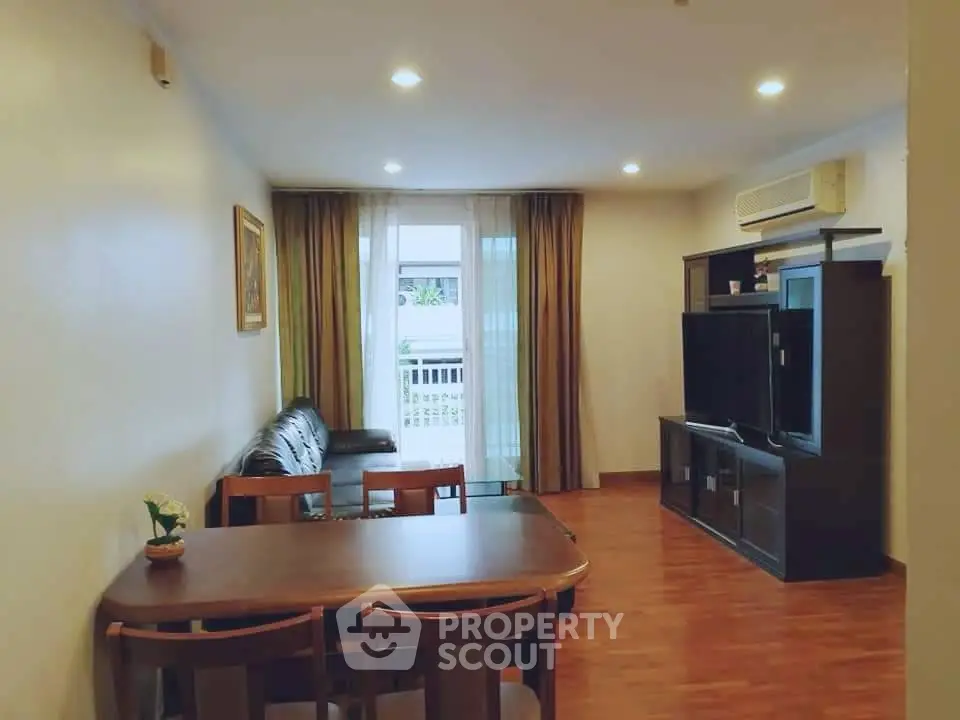 Spacious living room with modern furniture and large TV, perfect for relaxation and entertainment.